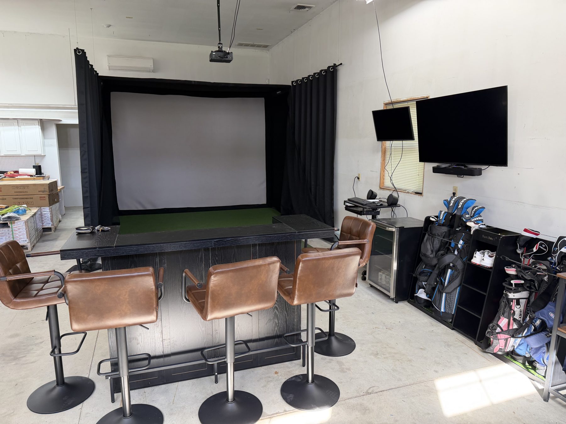 Garage golf simulator with bar seating area