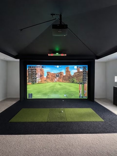 Loft golf simulator with projector and dark ceiling
