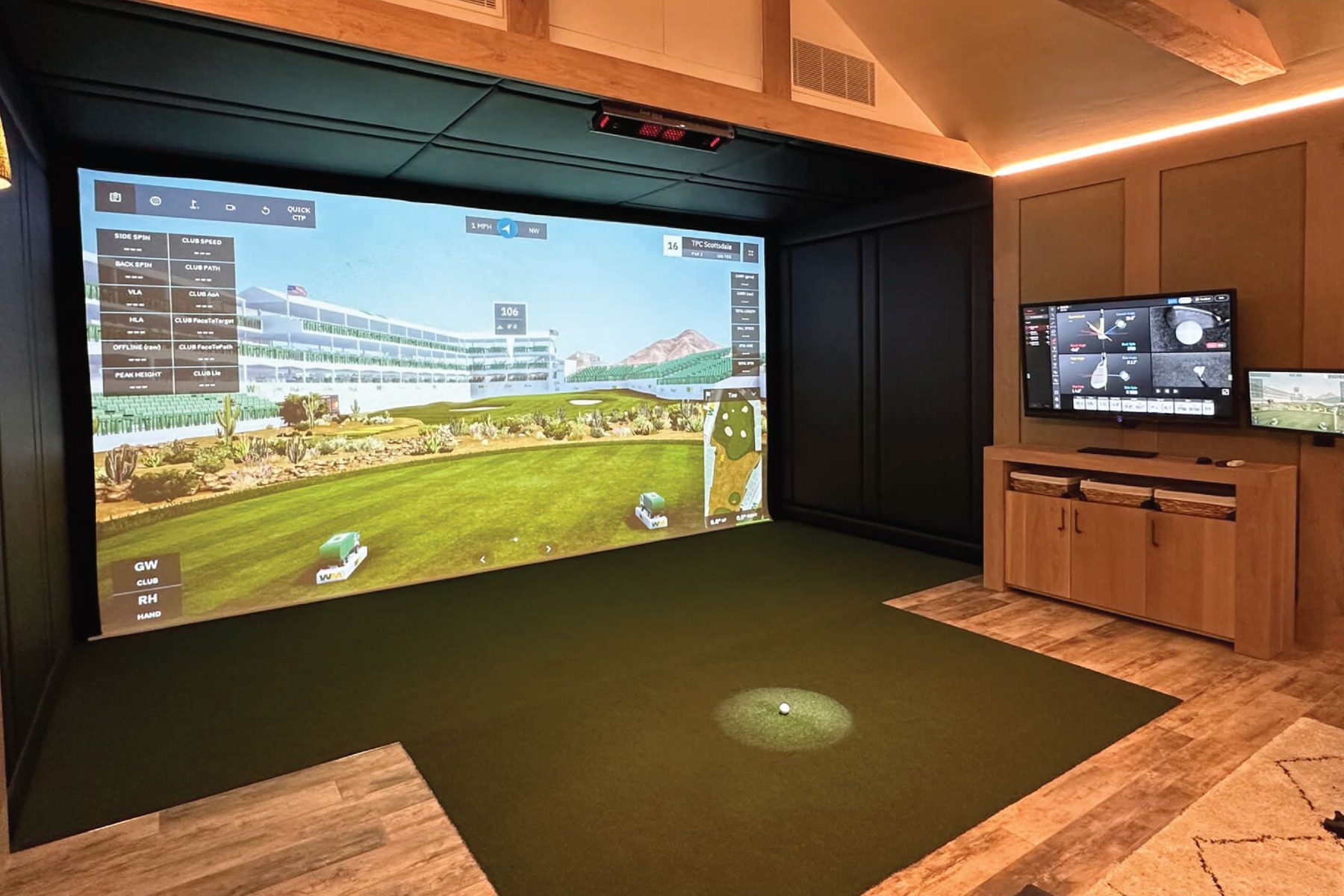 Outbuilding golf simulator with vaulted ceiling and warm lighting